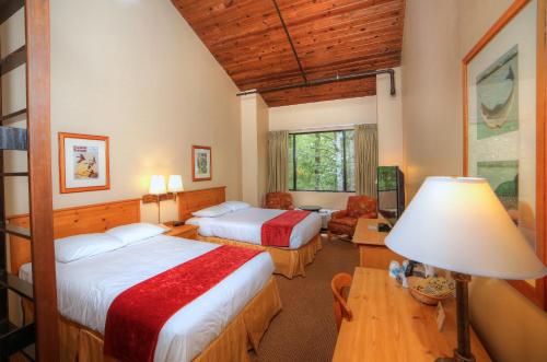 um quarto com 2 camas e uma mesa com um candeeiro em Unicoi State Park & Lodge em Helen