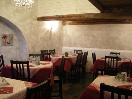 uma sala de jantar com mesas e cadeiras e um lustre em Agriturismo Mamma Chica em La Spezia
