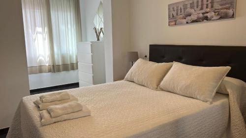 a bedroom with a bed with two towels on it at Apartamento Puente Romano in Córdoba