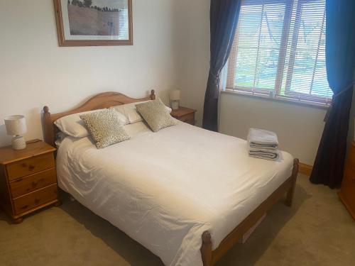 1 dormitorio con 1 cama con sábanas blancas y ventana en 3 The Courtyard Castle Dargan en Ballygawley