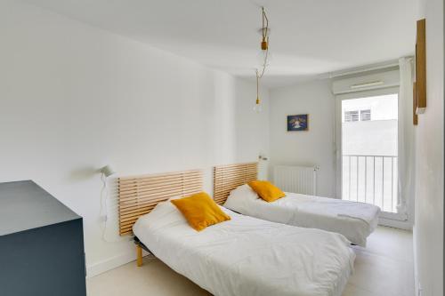 Duas camas num quarto com uma janela em "Le Massilia" Beau duplex avec balcon à Marseille em Marselha