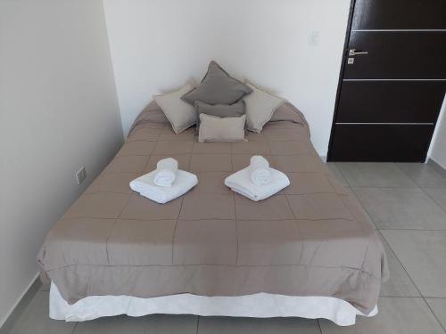 1 dormitorio con 1 cama con 2 toallas en Directo al Mar Suite en Puerto Madryn