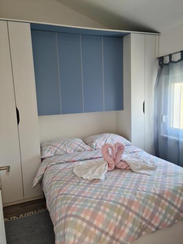 ein Schlafzimmer mit einem Bett mit rosa Kleidung in der Unterkunft Apartmani Rudi in Anić