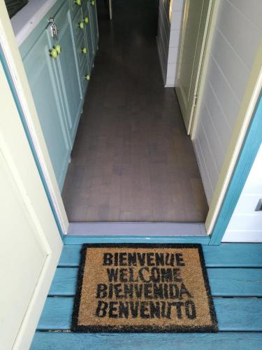 a welcome welcome rug on the floor of a hallway at Gîtes Les Perouilles - La Roulotte Climatisée avec Jacuzzi de Josépha in Puymiclan