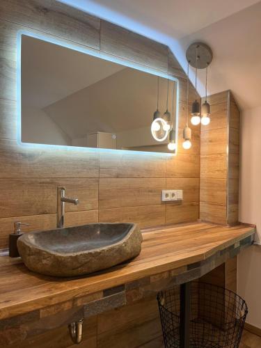 a bathroom with a stone sink and a mirror at Haus am Deich in Butjadingen