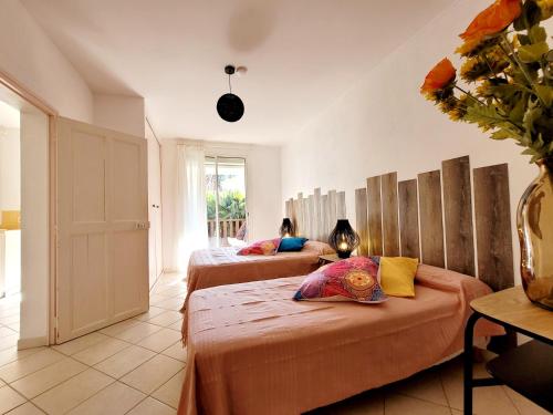 two beds in a room with two people sitting on them at RDC de Villa de 35 m2 - 400 m Plage in Six-Fours-les-Plages