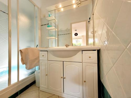 a white bathroom with a sink and a mirror at RDC de Villa de 35 m2 - 400 m Plage in Six-Fours-les-Plages