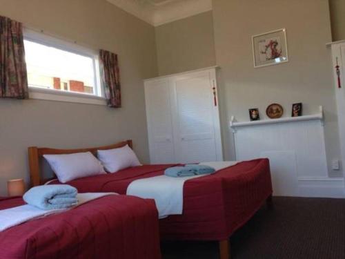 a bedroom with two beds with red and white sheets at Dunedin Classic Stay in Dunedin