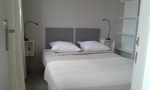 ein weißes Bett mit zwei Kissen darüber in der Unterkunft LE BLATIN in Clermont-Ferrand