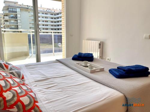 een bed met blauwe kussens in een slaapkamer bij APARTBEACH NOVA PINEDA con PARKING Y CLIMA in La Pineda