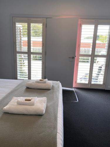 a bedroom with two beds with towels on them at The Dickins in Woodend