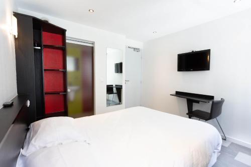 a bedroom with a white bed and a desk at Hotel Mimosa Paris in Paris