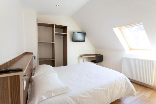 a bedroom with a white bed and a window at Hotel Mimosa Paris in Paris