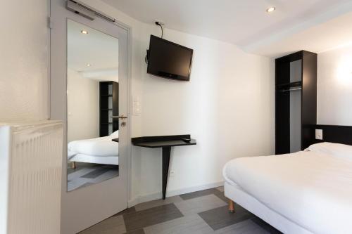 a bedroom with a mirror and a bed at Hotel Mimosa Paris in Paris