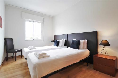 um quarto com uma cama grande e uma cadeira em Apartamento Antero III RRAL nº 743 em Ponta Delgada