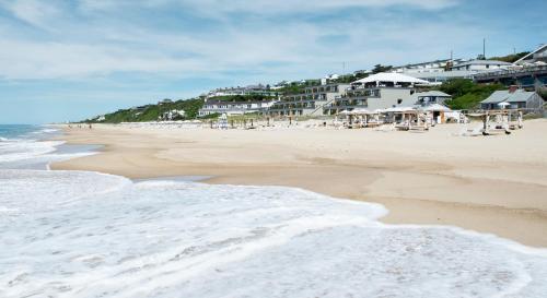 a beach with a group of buildings and the ocean at Gurney's Montauk Resort & Seawater Spa in Montauk