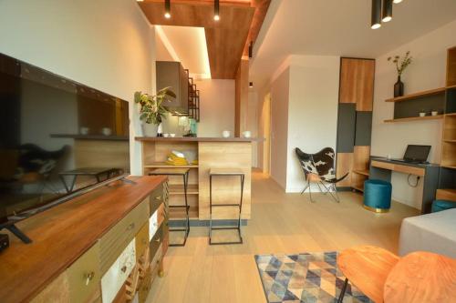 Una cocina y una sala de estar con mostrador y sillas. en STUDIO K district (central BG+private parking), en Belgrado