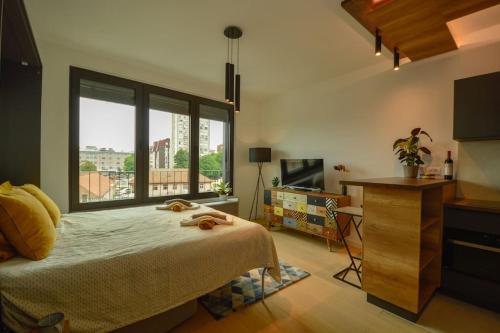 a bedroom with a bed and a large window at STUDIO K district (central BG+private parking) in Belgrade