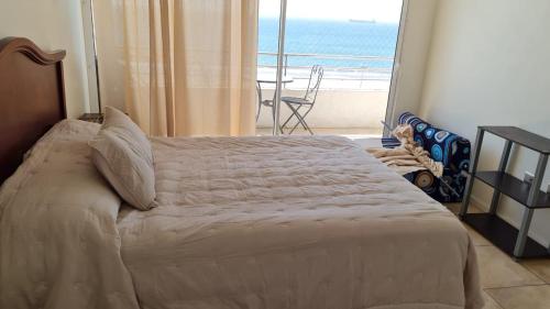 Schlafzimmer mit einem Bett und Meerblick in der Unterkunft Costa Peñuelas. Coquimbo in Coquimbo