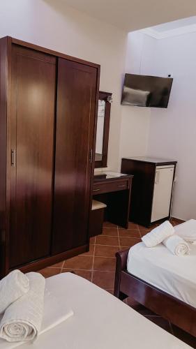 a hotel room with two beds and a wooden cabinet at Elena Rista Studios in Parga