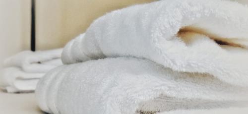 a stack of white towels sitting on a table at House with large terrace, jacuzzi and gated parking for one car in Montevideo