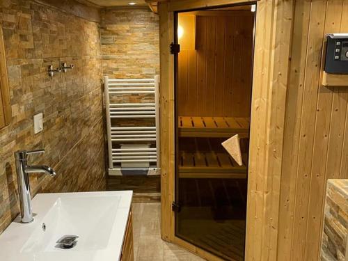 ein Badezimmer mit einem weißen Waschbecken und einer Dusche in der Unterkunft Gîte Le Menoux, 3 pièces, 5 personnes - FR-1-591-193 in Le Menoux