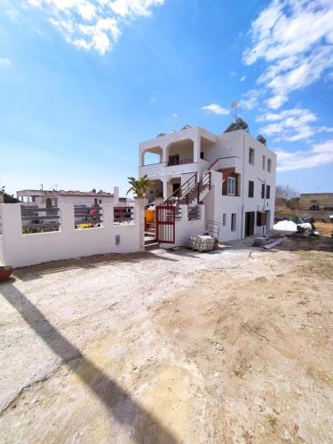 a large white house with a dirt yard at Casa con piscina 2 Camere da letto Profumo Sea & Sun 2A in Triscina