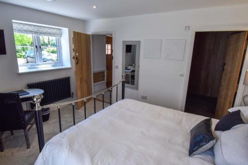 a bedroom with a bed and a desk and a window at Abbey Green Farm in Wem