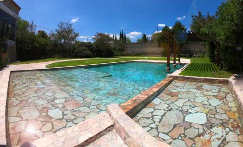 a swimming pool with rocks in a yard at Hacienda San Patricio in San Miguel de Allende