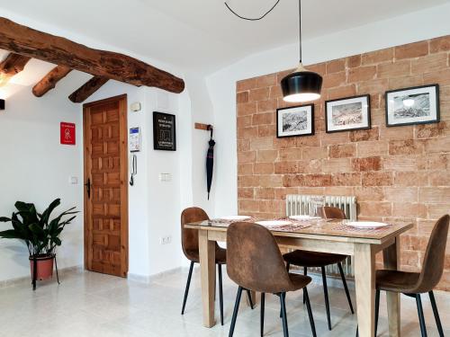 a dining room with a wooden table and chairs at LA MUNTANYA - Apartamentos Rural Guadalest in Benimantell