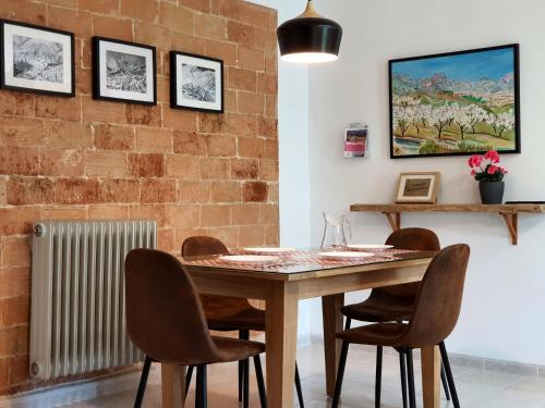 a dining room with a wooden table and chairs at LA MUNTANYA - Apartamentos Rural Guadalest in Benimantell