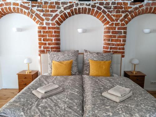 a bedroom with a bed with a brick wall at BacksteinFlair - LüneMitte in Lüneburg