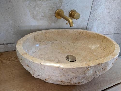a stone sink with a gold faucet in a bathroom at BacksteinFlair - LüneMitte in Lüneburg