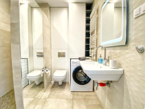 a bathroom with a sink and a washing machine at BP III Premium in Toruń
