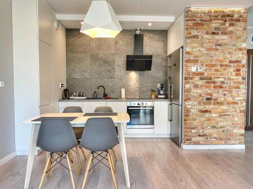 a kitchen with a table and chairs and a brick wall at BP III Premium in Toruń