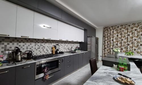 a kitchen with gray cabinets and a table and a counter at villa beridze in Borjomi