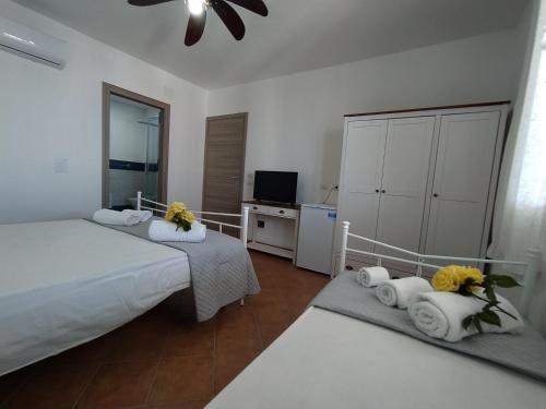 TriscinaにあるAPPARTAMENTO CON 3 CAMERE CON BAGNO INTERNO, CUCINA Sea & Sun 3のベッドルーム1室(ベッド2台、タオル、テレビ付)