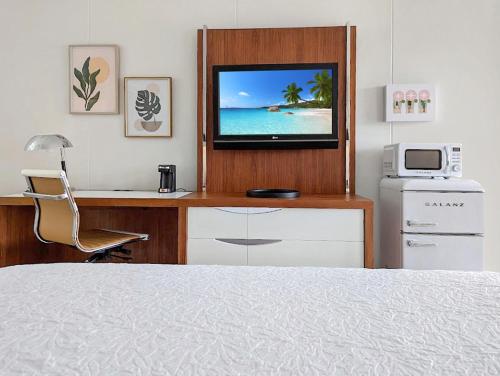a bedroom with a desk with a tv on top of it at The Inn On Main in Chincoteague