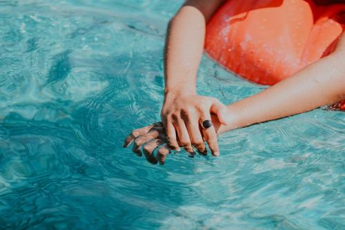una mujer en una piscina con su mano en el agua en The Inn On Main en Chincoteague