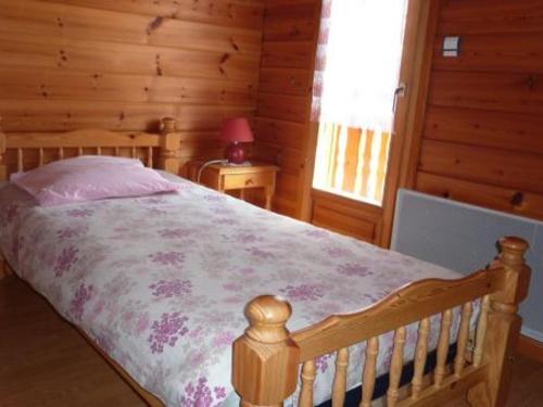 ein Schlafzimmer mit einem Bett in einem Blockhaus in der Unterkunft Gîte Le Menil, 5 pièces, 5 personnes - FR-1-589-107 in Le Ménil