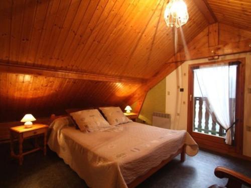 a bedroom with a large bed with a wooden ceiling at Gîte Le Val-d'Ajol, 2 pièces, 4 personnes - FR-1-589-135 in Le Val-dʼAjol