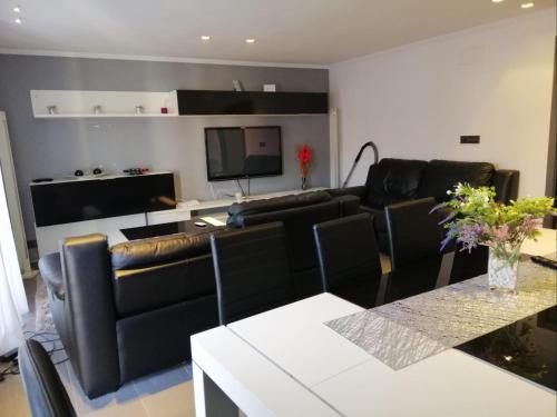 a living room with black leather furniture and a flat screen tv at Elche piso entero 3 dormitorios dobles in Elche