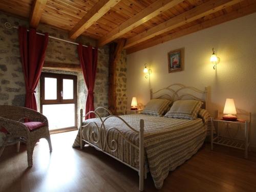 una camera da letto con un letto grande in una stanza di Maison de charme en Margeride: terrasse, terrain clos, proche Saugues et chemin St-Jacques - FR-1-582-146 a Saugues