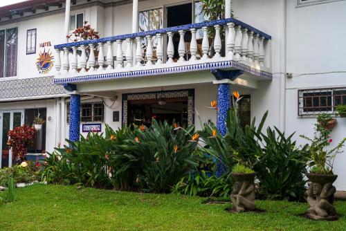 a building with a balcony and flowers in the yard at Hotel Ave del Paraíso in San José