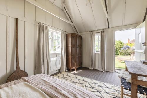 MardenにあるCosy Cottage with Beautiful Garden, HotTub & Saunaのベッドルーム1室(ベッド1台、テーブル、窓付)