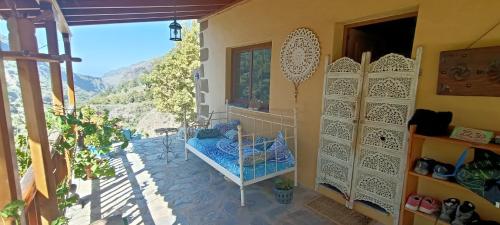 a room with a balcony with a bed and a window at Rivendell Eco lodge in El Paso