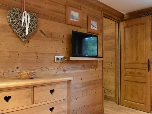 Cette chambre dispose d'une télévision et d'un mur en bois. dans l'établissement Appartement cosy avec cheminée, terrasse et parking, proche pistes et commerces - Méribel - FR-1-180-552, à Méribel