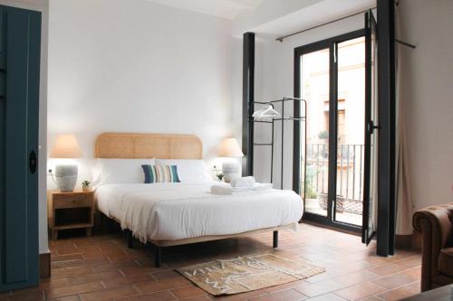 sypialnia z łóżkiem i dużym oknem w obiekcie MonKeys Apartments Pureza House w Sewilli