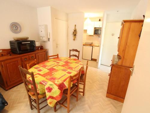 une salle à manger avec une table et une cuisine dans l'établissement Appartement T3 Sud avec Balcon et Parking à Bagnères-de-Luchon - 4 pers. - FR-1-313-178, à Luchon