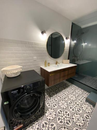 une salle de bain avec une machine à laver et un lavabo dans l'établissement Ajaccio magnifique T2 37m2 centre ville vue mer au bord de la plage Neuf 4 couchages balcon parking privé fermé Clim wifi, à Ajaccio